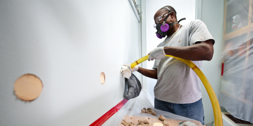 man installing wall insulation